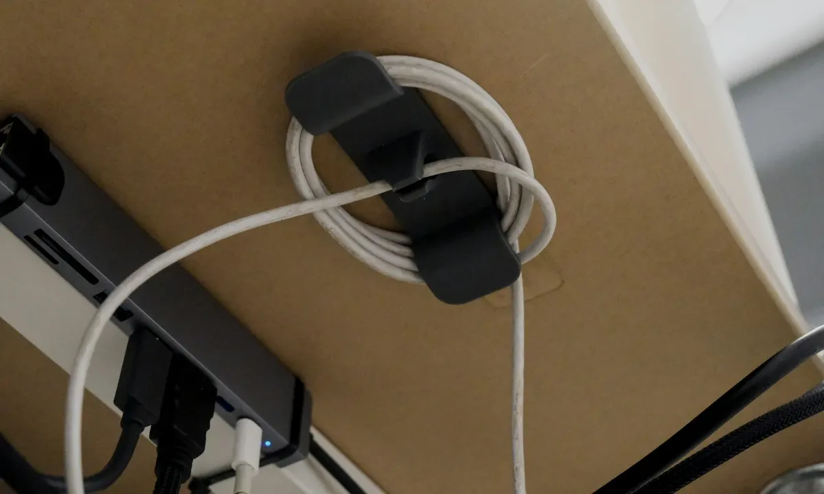 Coiled cable organizer mounted underneath a desk